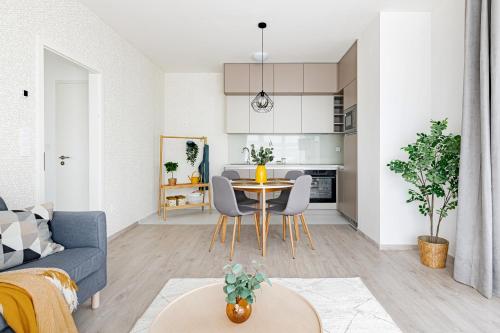 a living room and kitchen with a table and chairs at WestSide Garden Apartments by FirstHost in Budapest