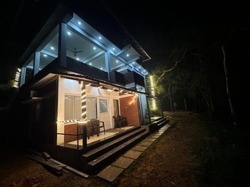 a house with blue lights on the front at night at Coorg Jungle Mist in Madikeri
