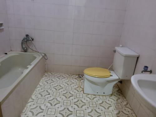 a bathroom with a toilet with a yellow lid at villa kumala in Tjikakaka