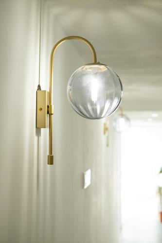 une lumière accrochée à un mur avec une porte dans l'établissement CASA MONICA CARGESE - Swing 42 - appartement, à Cargèse