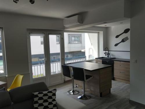 - une cuisine avec un îlot de cuisine dans le salon dans l'établissement Grand T2 tout équipé centre-ville, spacieux et lumineux, 1 chambre, 1 à 4 pers, possible 5 pers avec lit d'appoint pour 15 euros, climatisation, wifi, balcons, parking privé surveillé compris, à Lorient