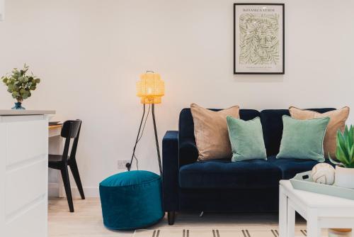 a living room with a blue couch with pillows at Luxury 1 bed flat in Milton Keynes