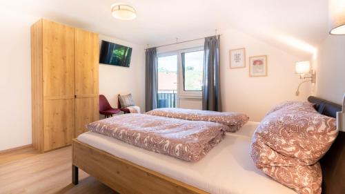 una camera da letto con due letti e una finestra di Ferienwohnung Weitblick a Durbach