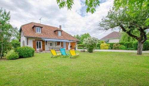 three chairs sitting in the yard of a house at La mylardiere in Piney