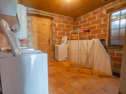 a room with a brick wall and a white refrigerator at La mylardiere in Piney