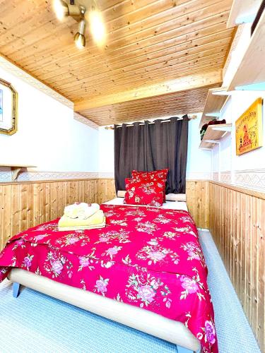 a bedroom with a large red bed in a room at Ferienhaus Daddy Bernd in Niederstadtfeld