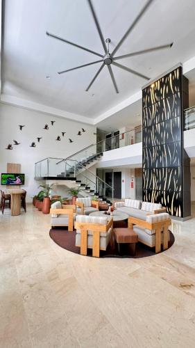 a living room with couches and tables and a staircase at Hotel Morúa in Yopal