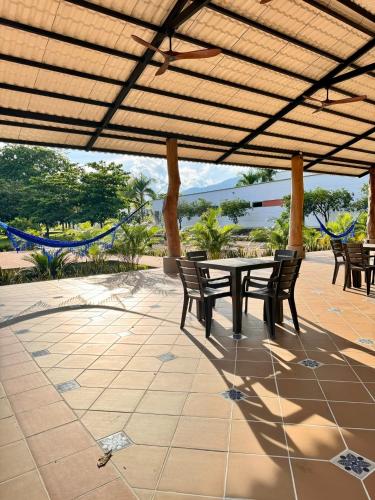 a patio with a table and chairs under a pergola at Hotel Morúa in Yopal