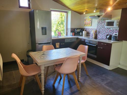 a kitchen with a table and chairs in it at Mas de Bouilhac Gite et Insolite in Pranles