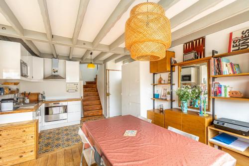 une cuisine et une salle à manger avec une table et un lustre dans l'établissement GuestReady - Great ap near Buttes Chaumont Park, à Paris