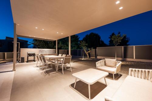 a patio with a table and chairs and a table and chairsktop at Terra Petra Luxury Villas by Travel Pro Services- Vourvourou Halkidiki in Vourvourou