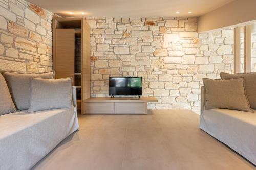 a living room with two couches and a tv at Terra Petra Luxury Villas by Travel Pro Services- Vourvourou Halkidiki in Vourvourou