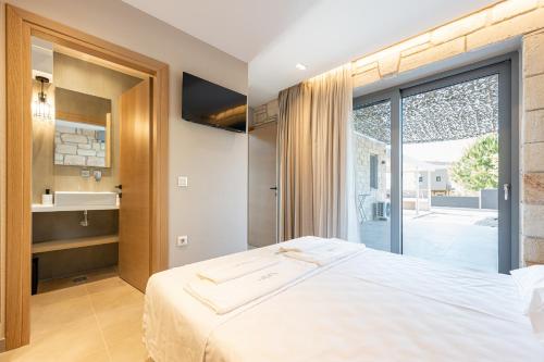 a bedroom with a bed and a large window at Terra Petra Luxury Villas by Travel Pro Services- Vourvourou Halkidiki in Vourvourou