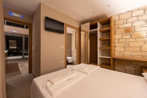 a bedroom with a bed and a tv on the wall at Terra Petra Luxury Villas by Travel Pro Services- Vourvourou Halkidiki in Vourvourou
