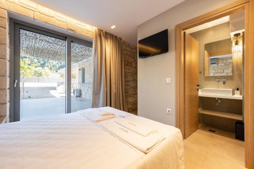 a bedroom with a large bed and a sliding glass door at Terra Petra Luxury Villas by Travel Pro Services- Vourvourou Halkidiki in Vourvourou
