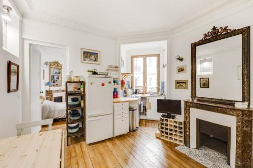Elle comprend un salon doté d'une cheminée et d'un réfrigérateur blanc. dans l'établissement GuestReady - Apt cosy près du Jardin des Plantes, à Paris