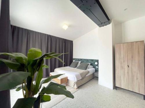 une chambre avec un lit et une plante en pot dans l'établissement Villa Malmousque avec accès mer privé, à Marseille