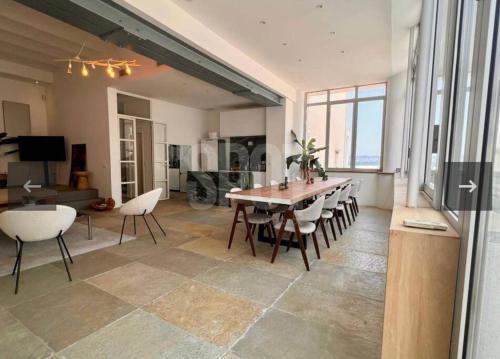 un grand salon avec une table et des chaises dans l'établissement Villa Malmousque avec accès mer privé, à Marseille