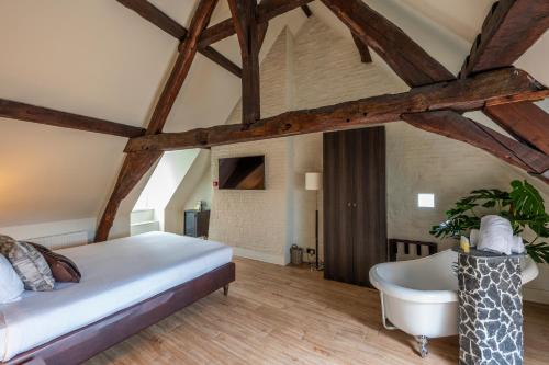 a bedroom with a large bed and a bath tub at Hotel Onderbergen in Ghent