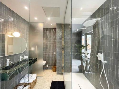 une salle de bain avec une douche avec une porte vitrée dans l'établissement Villa Malmousque avec accès mer privé, à Marseille