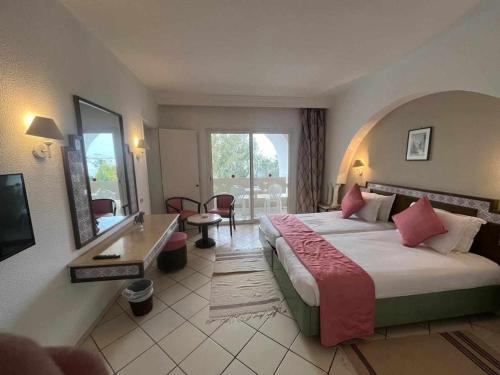 Tunisia Lodge في الحمامات: غرفة الفندق بسرير كبير ومكتب