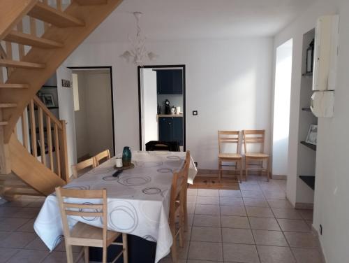 une cuisine et une salle à manger avec une table et des chaises dans l'établissement L'oustal, à Teyssieu