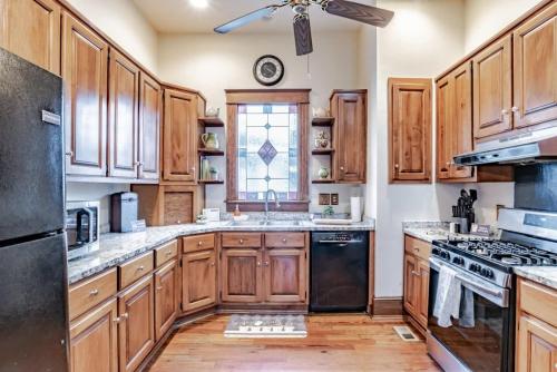 a large kitchen with wooden cabinets and a window at Heavenly on Hunter-Historic Grandeur-The Cannon in Mobile