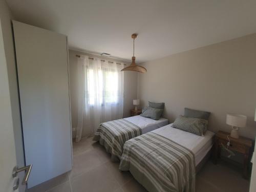 une chambre avec deux lits et une fenêtre dans l'établissement l'éden des Baronnies, à Mirabel-aux-Baronnies