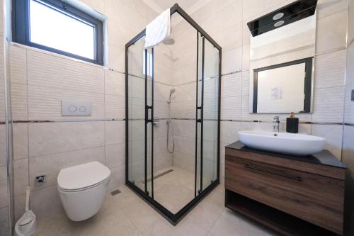 a bathroom with a shower and a toilet and a sink at Mediterranean Breeze Villa - Family-Friendly Luxury Villa - Fethiye by Sunworld Villas in Fethiye