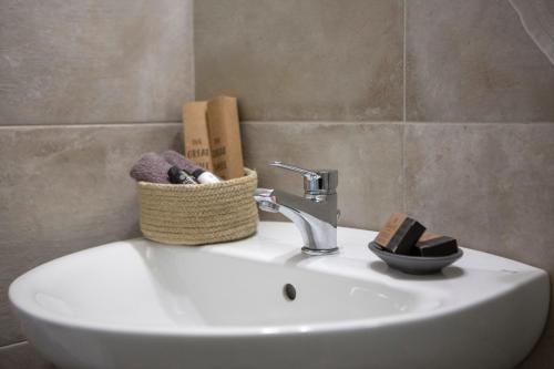 a bathroom sink with a basket on top of it at Athina résidence in Nydri