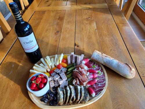 a plate of food and a bottle of wine on a table at Mas de Bouilhac Gite et Insolite in Pranles