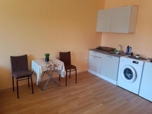 une cuisine avec une table et des chaises ainsi qu'un lave-linge dans l'établissement Homex #Varna-Autogara, à Varna
