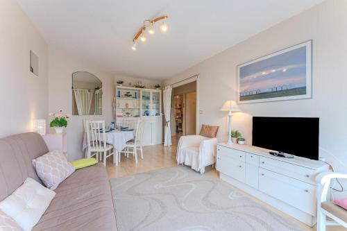 un salon avec un canapé et une télévision à écran plat dans l'établissement Appartement Barca - Welkeys, à Arcachon