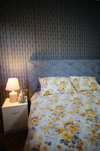 a bedroom with a bed with a blue and white comforter at Lux11 in Sombor