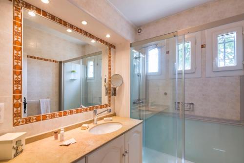 a bathroom with a shower and a sink and a mirror at La Saliniere in Roquefort-les-Pins