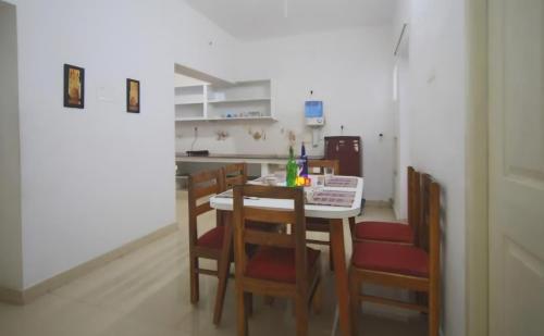 ポンディシェリにあるVILLA MAHALI ROCK BEACH FRONT 2BHK villaのテーブルと椅子のあるキッチンとダイニングルーム