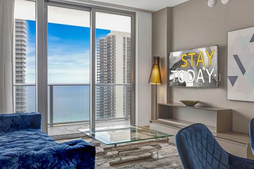 a living room with a blue couch and a glass table at HYDE HOUSE - Luxury Waterfront 2BR 2BA Apartment Suite with direct ocean view, roof top pool, resort amenities in Hollywood