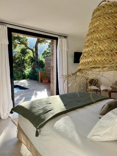 une chambre avec un grand lit avec une grande fenêtre dans l'établissement Casa Suvara - Chambres d'hôtes de charme I Piscines ou SPA privatifs, à Conca