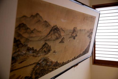 a painting of mountains on a wall next to a window at Ryokan Wataya in Karatsu