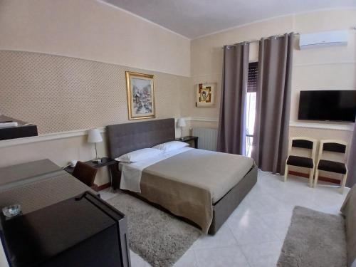a hotel room with a bed and a television at La Suite del Vulcano in Belpasso