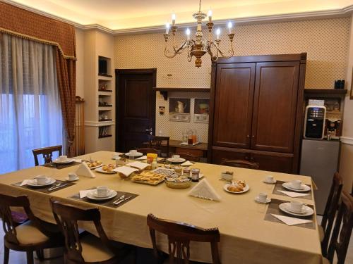 a large dining room table with chairs and a chandelier at La Suite del Vulcano in Belpasso