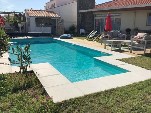 une piscine avec de l'eau bleue dans une cour dans l'établissement L’ écume de mer, à La Chaume
