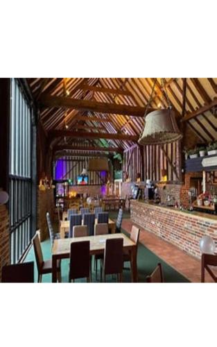 a restaurant with tables and chairs and a bar at Golf and Leisure Retreat in Great Yarmouth