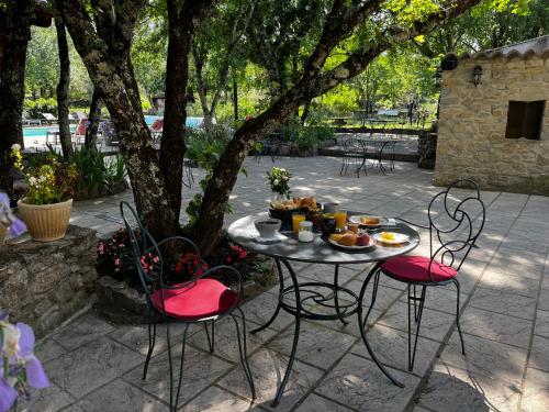 a table with food on it sitting on a patio at Hôtel Mas de l'Espaïre in Les Vans