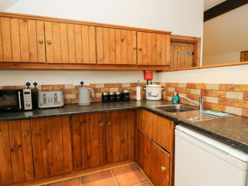 a kitchen with wooden cabinets and a counter top at The Steading in Dalmally