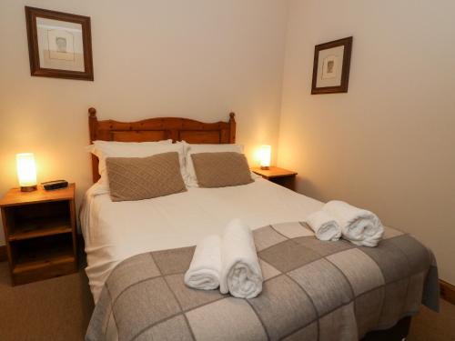 a bedroom with a bed with towels on it at The Steading in Dalmally