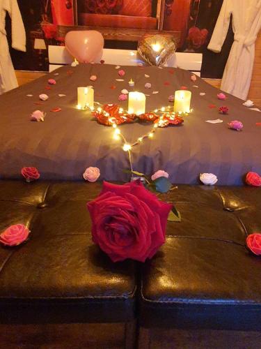a table with a rose and candles on it at Le temps suspendu in Trèbes