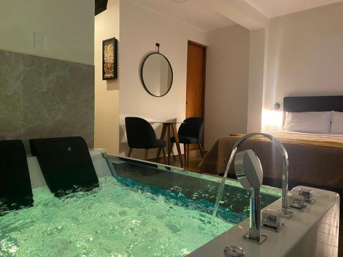 a jacuzzi tub in a room with a bedroom at Hotel Alba in Ica