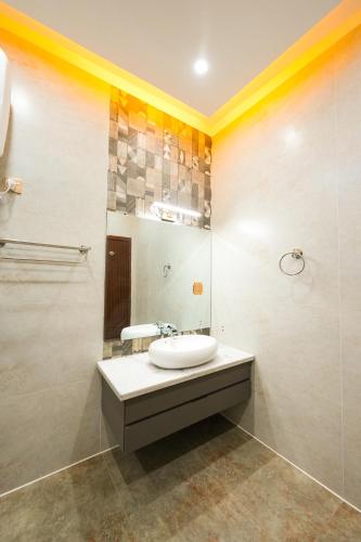 a bathroom with a sink and a mirror at Pavilion Suites - Premium ApartHotel in Bahria Town in Rawalpindi