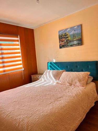 - une chambre avec un lit doté d'une tête de lit bleue et d'une fenêtre dans l'établissement Hospedaje Central Lord Cochrane 1121, à Osorno